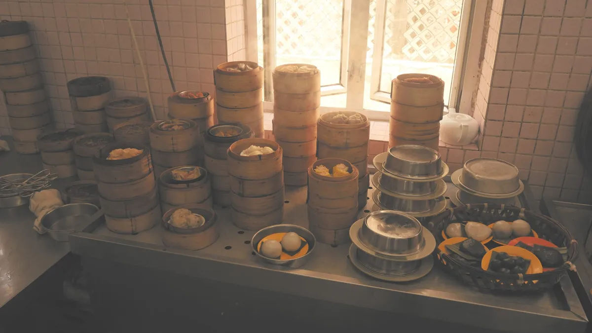 Stacks of bamboo dim sum steamers on a counter by a window
