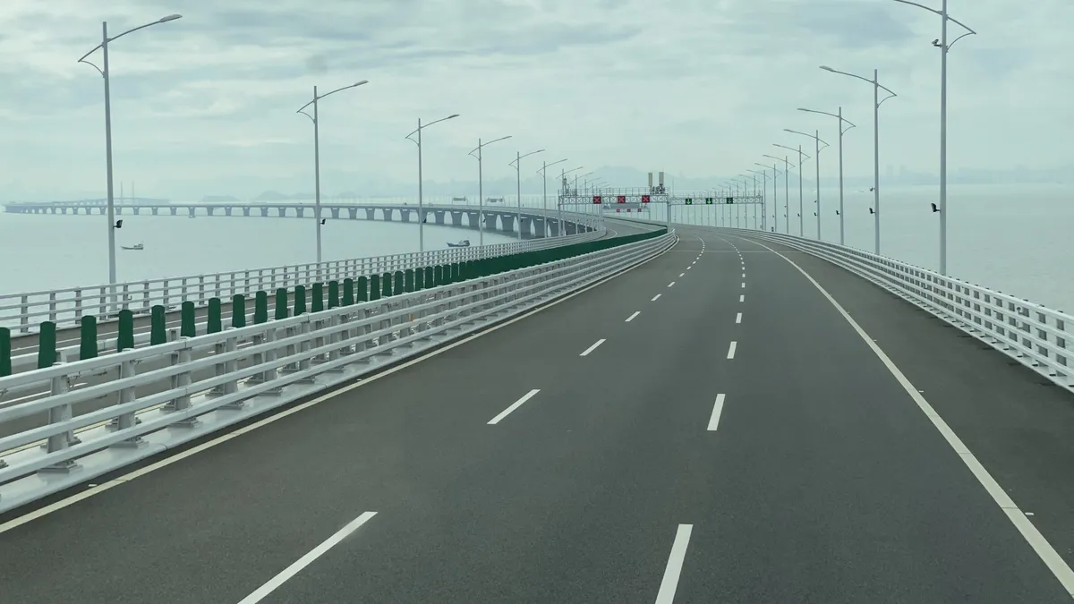 An empty highway on a bridge stretching towards the horizon under a pale sky