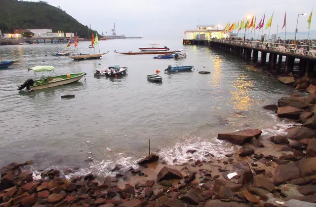 An island pier at dusk with small boats in the bay