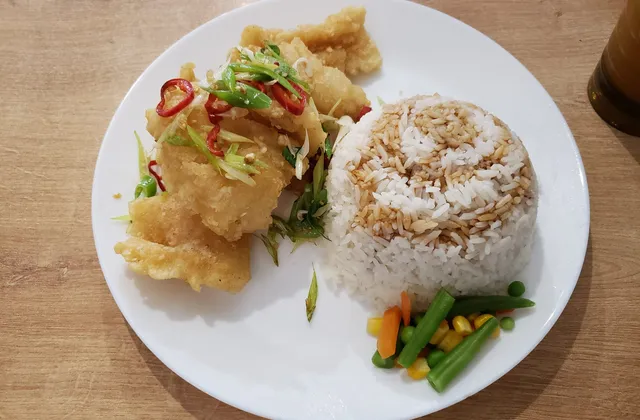 Salt and pepper squid with rice and vegetables on a white plate